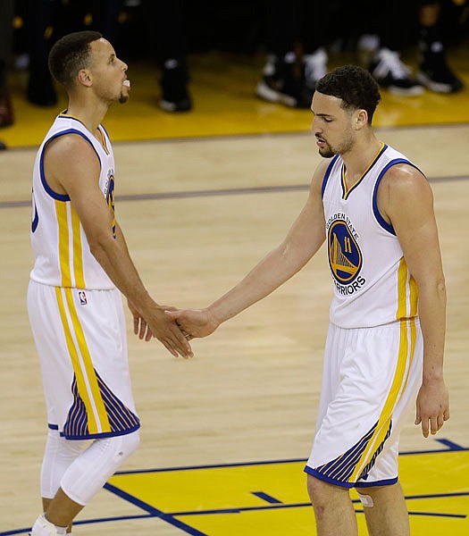 Golden State Warriors' Stephen Curry, left, and Klay Thompson celebrate a score against the Portland Trail Blazers during the second half in Game 5 of a second-round NBA basketball playoff series, Wednesday, May 11, 2016, in Oakland, Calif. The Warriors advanced to the conference finals with a 125-121 win. 