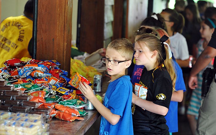 Keevan Soval, a student at North School in Holts Summit, grabs a sandwich and other items as he and other fifth graders go through the food line during the Safety Patrol Picnic Friday at Memorial Park in Jefferson City. 