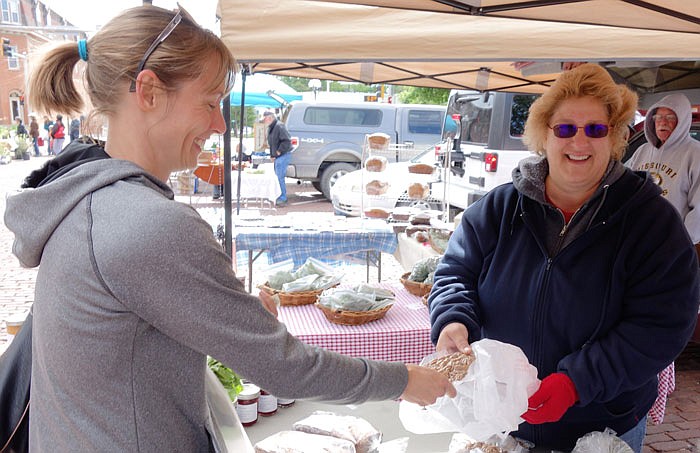 Fulton resident Jonna Neterer purchases locally grown produce Saturday morning, May 14, 2016, at the Fulton Farmers Market.