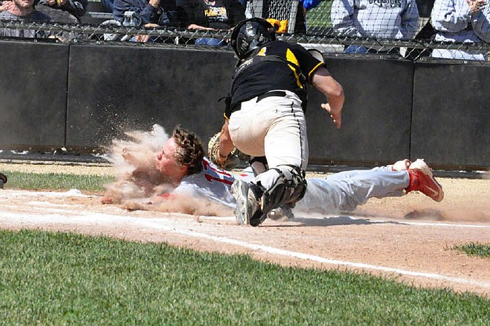 Fulton junior catcher Isaiah Pani tags out Mexico senior second baseman Tanner Smith at home plate in the first inning of Saturday afternoon's Class 4, District 8 semifinal at the high school athletic complex.