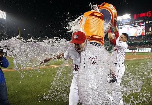 Washington Nationals starting pitcher Max Scherzer is doused by catcher Wilson Ramos after the Nationals defeated the Detroit Tigers in a baseball game at Nationals Park, Wednesday, May 11, 2016, in Washington. Scherzer struck out 20 batters, tying the major league nine-inning record.