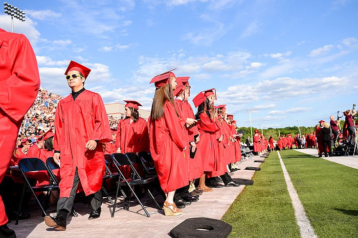 Jefferson City High School seniors leave their seats to take the stage and get their diplomas at Sunday's commencement ceremony.