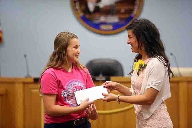 Audrey Ickes, 13, left, receives an award from Mayor Carrie Tergin during the Heritage Day Celebration on Tuesday at the Jefferson City Council Chambers. The ceremony distributed awards for artwork (by local students) of historic properties and awards to owners of historic properties. 