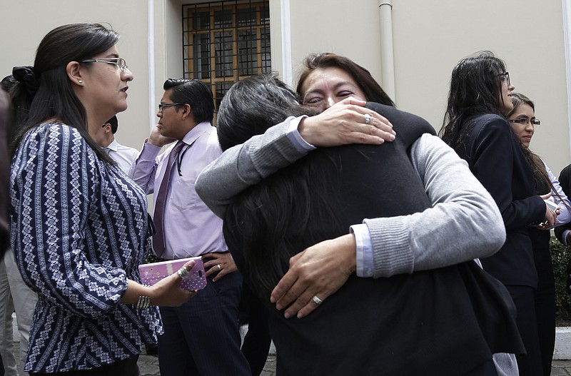 Foreign Ministry staff hug after evacuating their offices following one of two tremors felt in Quito, Ecuador, Wednesday, May 18, 2016. Both tremors were centered along the Pacific coast near the epicenter of last month's magnitude-7.8 quake and rattled homes as far away as the capital. Neither appeared to have caused serious damage. 