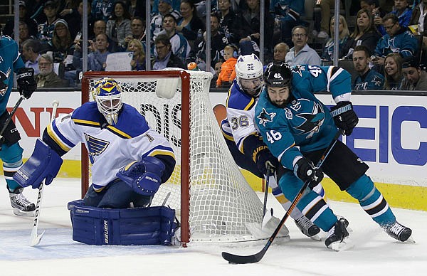 The Sharks' Roman Polak (right) skates past the Blues' Troy Brouwer to take a shot on goalie Brian Elliott during the first period Thursday's Western Conference finals games in San Jose.