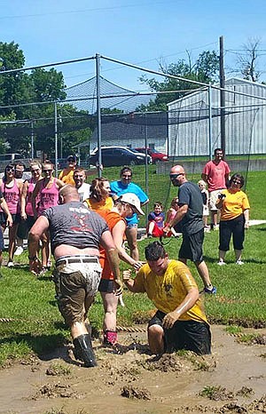 Partipants in the tug-of-war event during Fulton's 2015 street fair are one with the mud.