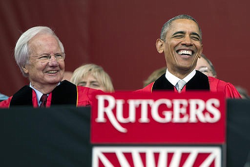 In this May 15, 2016 file photo, President Barack Obama, right, laughs as he sits with Bill Moyers during Rutgers University's 250th Anniversary commencement ceremony in Piscataway, N.J. Colleges that pay for celebrities say it can impress donors and attract the attention of potential students. But steep costs for some speakers have drawn criticism in some years. According to documents obtained by The Associated Press through records requests, Rutgers University paid a $35,000 speaking fee to Moyers, even though he was later replaced as keynote speaker by Obama, who wasn't paid a fee.