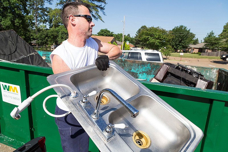 Jeff Mays tosses away a kitchen sink Saturday, May 21, 2016 in the parking lot of Vera Kilpatrick School. "I stretched before I came here," he said. Texarkana, Ark.'s City Beautiful Commission partnered with Texarkana, Texas' Keep Texarkana Beautiful Committee, Waste Management and Leadership Texarkana to organize a community cleanup and provide free dumpsters around the city. 
