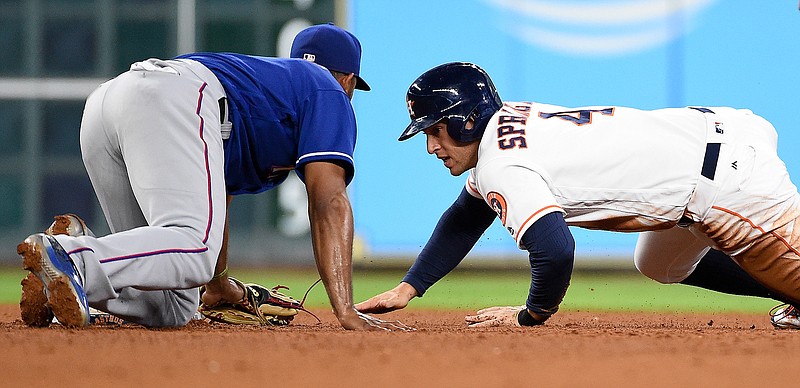 Houston Astros' George Springer, right, tries to touch second base on a steal attempt as Texas Rangers shortstop Elvis Andrus looks to make the tag during the fourth inning of a baseball game, Saturday, May 21, 2016, in Houston. Springer was tagged out.