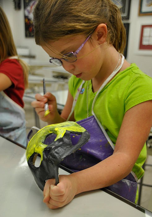 Casey Cramer paints a mask at a previous Kemper Kids art camp.