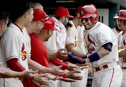 St. Louis Cardinals' Yadier Molina, right, is congratulated by teammates in the dugout after hitting a two-run home run during the seventh inning of a baseball game against the Arizona Diamondbacks, Saturday, May 21, 2016, in St. Louis. 