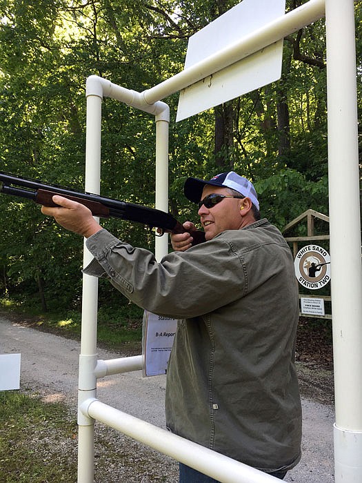 A shooter is ready for another target at a station on a sporting clay course.