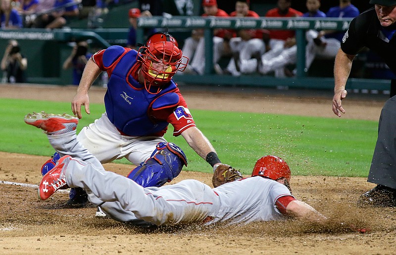 Los Angeles Angels' Shane Robinson, bottom, is tagged out at home by Texas Rangers catcher Bryan Holaday during the sixth inning of a baseball game in Arlington, Texas, Tuesday, May 24, 2016. 