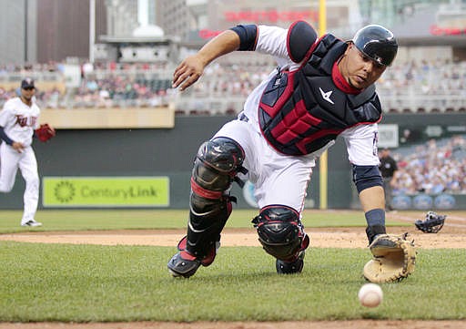 Minnesota Twins catcher Juan Centeno chases the ball down as Twins pitcher Ervin Santana runs to the plate too late to stop Kansas City Royals Cheslor Cuthbert from scoring in the fourth inning during a baseball game on Tuesday, May, 24, 2016 in Minneapolis.