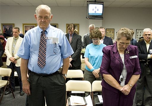 In this Sept. 24, 2010 file photo, Anthony Bruner and Mary Lou Bruner, right, pray at the start of a meeting of the Texas State Board of Education in Austin, Texas. (Jay Janner/Austin American-Statesman/Statesman.com via AP File)