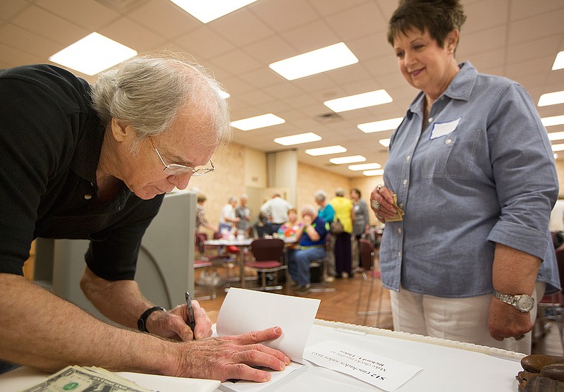  Author Richard Fluker signs a copy of "The Cows are Out" for Debbie Proctor on Wednesday, May 25, 2016 during the Texarkana chapter of the Texas Retired Teachers Association's monthly meeting at the TISD Services building on Wheeler Street. Fluker's book of short stories is about the life of "a farm kid in the 50's." The local retired teachers association has about 200 local members. Proctor retired from teaching first grade at Spring Lake Park Elementary.  