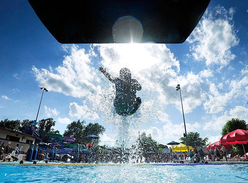 A swimmer sails off a water slide before plunging into the pool at Memorial Park Family Aquatic Center in Jefferson City on Saturday, June 20, 2015.