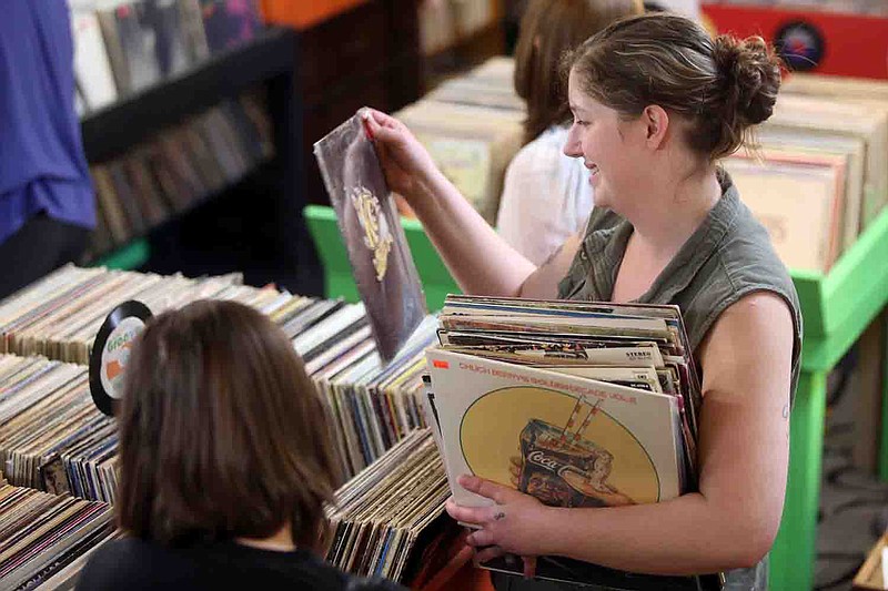 Alexandria Koetters holds an armful of records at In the Groove Records in Jefferson City. According to the Recording Industry Association of America, vinyl records are making a comeback.