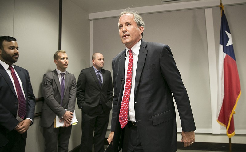 Republican Texas Attorney General Ken Paxton walks away Wednesday May 25, 2016, after announcing Texas' lawsuit to challenge President Obama's transgender bathroom order during a news conference in Austin. Texas and 10 other states are suing the Obama administration over its directive to U.S. public schools to let transgender students use the bathrooms and locker rooms that match their gender identity.