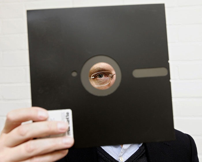 An obsolete 81/2-inch floppy disc  is held in London. Congressional investigators say the government spends about three-fourths of its technology budget maintaining aging computer systems. That includes platforms more than 50 years old in such vital areas as nuclear weapons and Social Security. One still uses floppy disks.