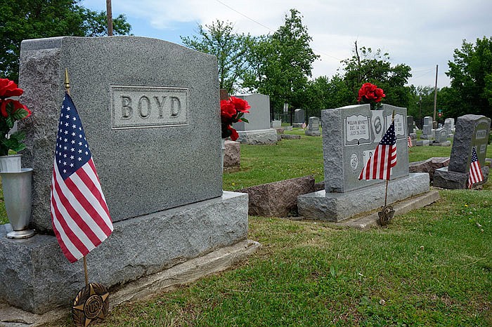 The graves of Bill Boyd, a World War II Marine, and his wife Mary Lee, lie next to the graves of his parents. Boyd's father Clyde is a veteran of World War I, and both graves are marked with American flags honoring them this Memorial Day weekend.