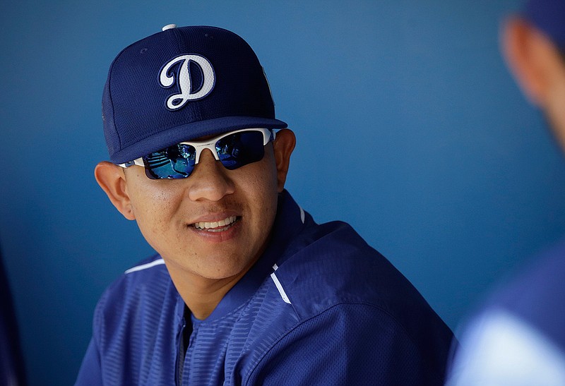In this March 14, 2016, Los Angeles Dodgers pitcher Julio Urias smiles while talking to teammates in the dugout during a spring training baseball game against the Milwaukee Urias, 19, is set to make his highly anticipated major league debut for the Dodgers on Friday night, May 27, 2016, in New York against the Mets