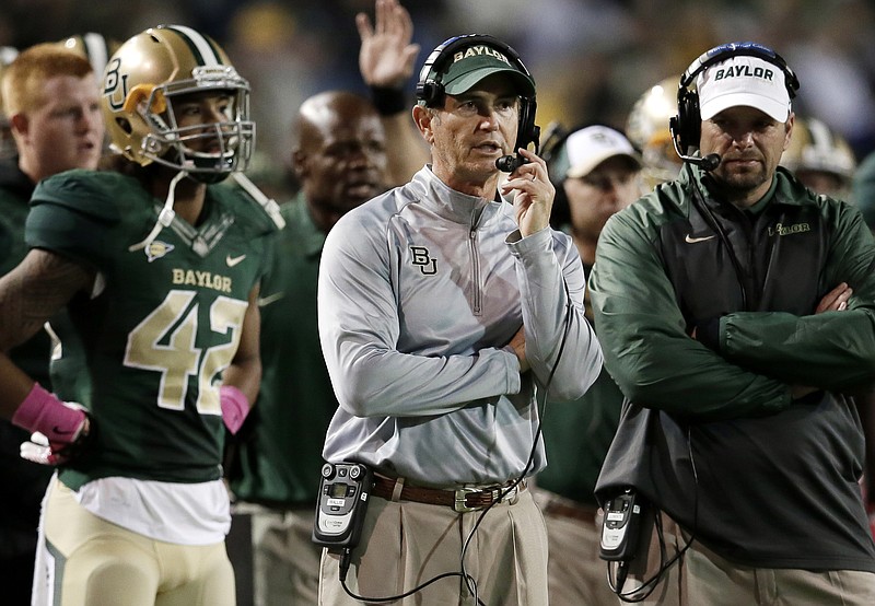 In this Oct. 19, 2013, file photo, Baylor head coach Art Briles, center, watches during the second half of an NCAA college football game against Iowa State in Waco, Texas. Baylor University's board of regents says it will fire Briles and re-assign university President Kenneth Starr in response to questions about its handling of sexual assault complaints against players.  The university said in a statement Thursday, May 26, 2016, that it had suspended Briles "with intent to terminate."  Starr will leave the position of president on May 31, but the school says he will serve as chancellor.