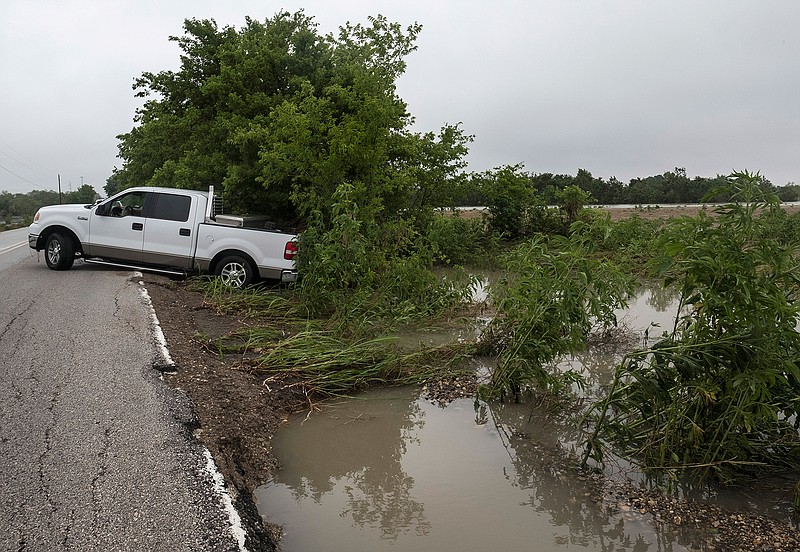 A pickup truck, that was washed off of Von Quintus Road during overnight flooding, rests on the side of the road in southeast Travis County, Friday, May 27, 2016, near Austin, Texas, on Friday, May 27, 2016. 