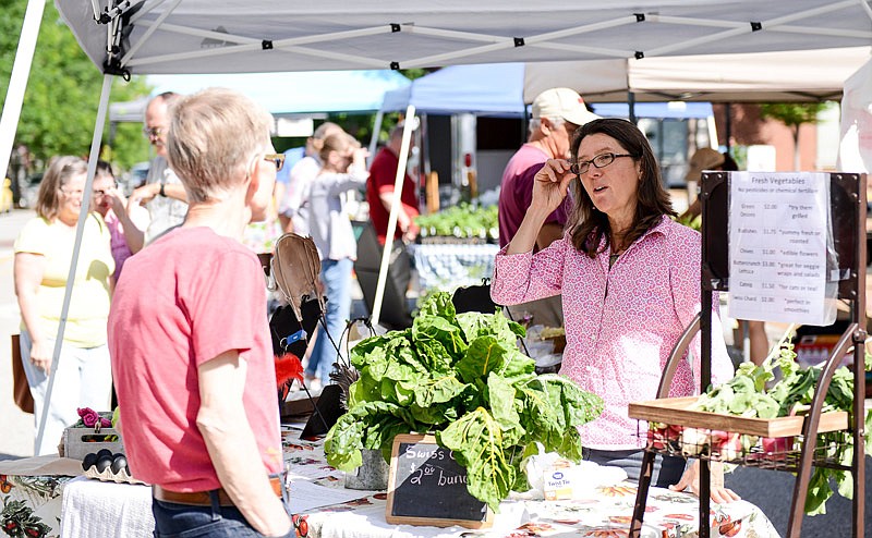 Organic farmer Colleen Meredith, informs an interested customer about her produce and other handmade goods.