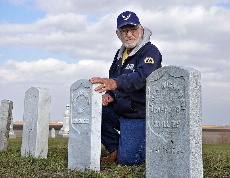 In this Nov. 15, 2015 photo, Harold Schook an Air Force veteran who every year at this time plants small American flags near area veterans' graves examines some of the new Civil War-era gravestones belonging to soldiers at the Odell Township Cemetery in Odell, Ill. High school students in Odell discovered the names of several Civil War veterans whose gravestones were battered by decades of rain, wind, snow and pollution and were replaced with new ones. "These kids gave these men their identity back," said Schook.