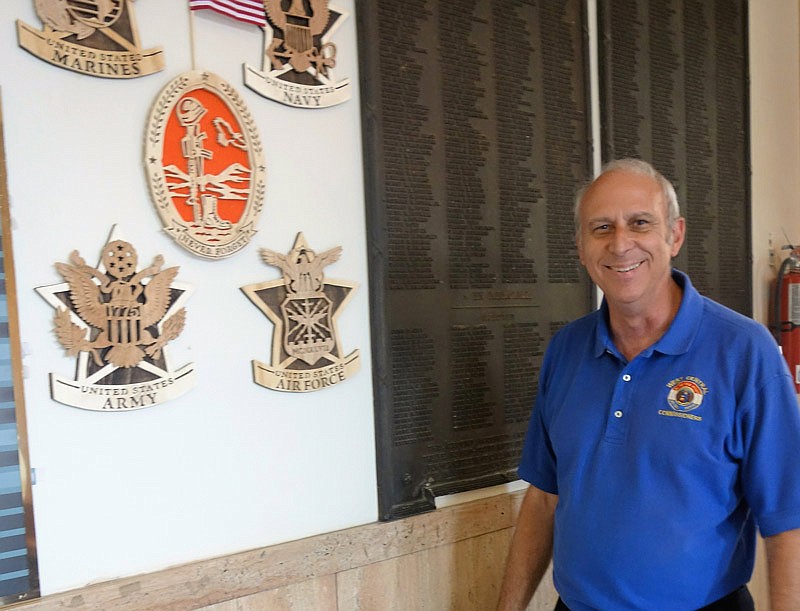 Doc Kritzer, Western District County commissioner, stands by plaques hanging inside the Callaway County Courthouse commemorating the service of county residents.