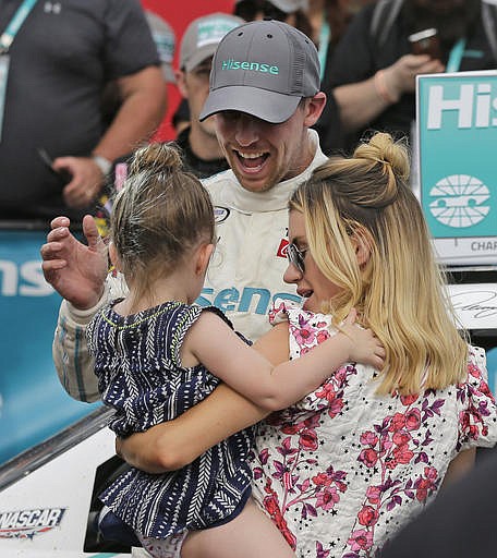 Denny Hamlin, center, celebrates in Victory Lane with his girlfriend Jordan Fish, right, and their daughter Taylor James Hamlin, left, after winning the NASCAR Xfinity series auto race at Charlotte Motor Speedway in Concord, N.C., Saturday, May 28, 2016.
