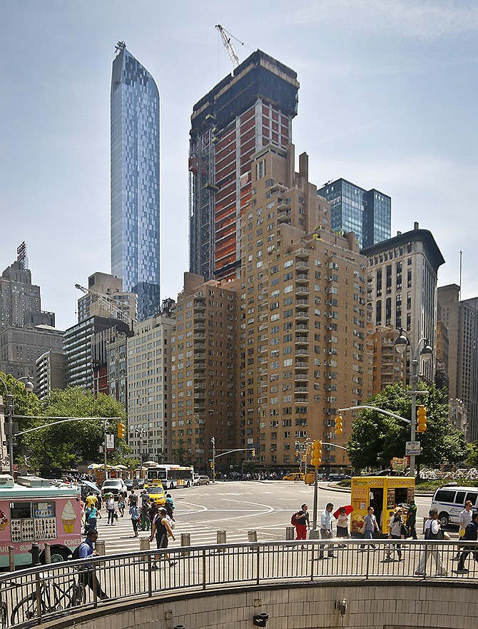 A luxury 90-floor apartment skyscraper called "One57," left, rises above all other buildings overlooking Central Park, while a crane sits atop ongoing construction for a new condominium skyscraper Thursday at 220 Central Park South, New York. A penthouse in One57 went for $100.5 million in 2014, but an apartment in the new condominium is expected to sell for $250 million.