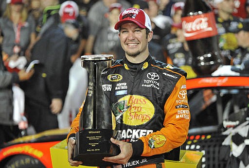 Martin Truex Jr poses with the trophy after winning the NASCAR Sprint Cup series auto race at Charlotte Motor Speedway in Concord, N.C., Sunday, May 29, 2016.