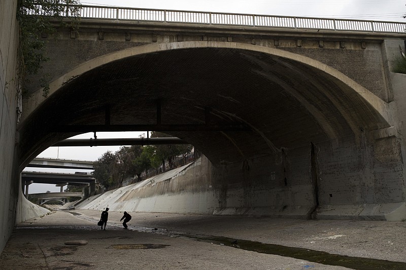 Two homeless men walk under the bridge along the Los Angeles River on May 16 in Los Angeles, where almost extinct form of American hieroglyphics known as hobo graffiti were discovered.
