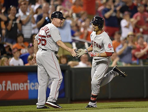 Boston Red Sox' Mookie Betts, right, is greeted by third base coach Brian Butterfield (55) after he hit a home run during the seventh inning of a baseball game against the Baltimore Orioles, Tuesday, May 31, 2016, in Baltimore. Betts hit three home runs in the game as the Red Sox won 6-2.