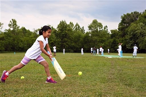 In this photo taken Friday, May 20, 2016, Anusha Bhaghwat, 7, of Lake St. Louis, works on batting during practice with the American Cricket Academy at the O'Fallon Sports Park in O'Fallon, Mo. (Cristina M. Fletes/St. Louis Post-Dispatch via AP)