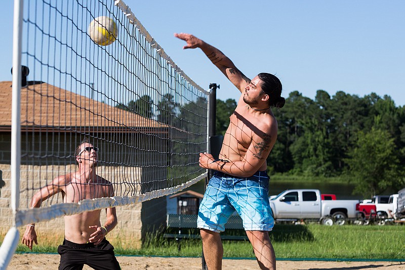 William Bullock knocks a volleyball over the net as Sheppard Screen attempts to recover Sunday, June 5, 2016 at Bringle Lake Park. Their group of friends plays weekly and met through casual volleyball matches. "It keeps us off the streets," Screen said. 