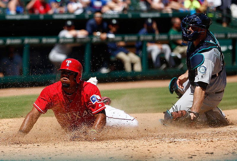 Texas Rangers shortstop Elvis Andrus (1) slides home in front of the tag by Seattle Mariners catcher Chris Iannetta (33) during the fifth inning on Sunday, June 5, 2016, at Globe Life Park in Arlington, Texas.