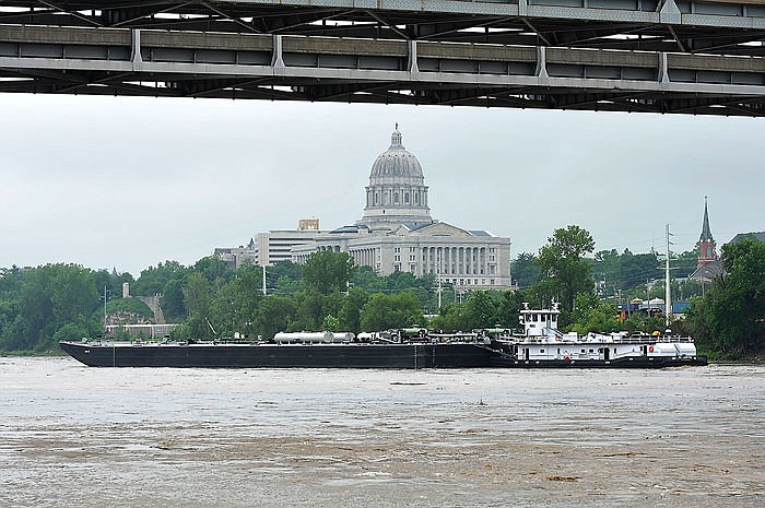 A tugboat pushed a barge down the Missouri River past the U.S. 54/63 bridge, as seen in this June 2016 photo.