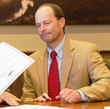 In this January 2015 file photo, Bob Ziehmer, in his capacity as director of the Missouri Department of Conservation, signs contracts providing federal funds to the state agency for habitat conservation by private landowners.