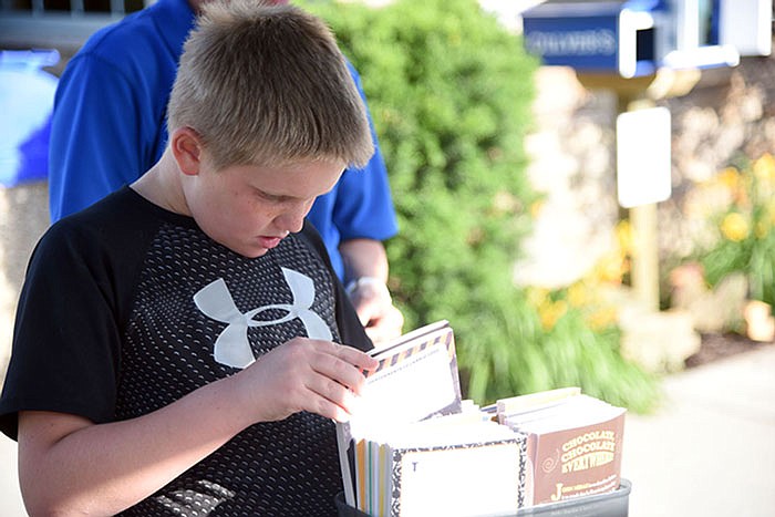 Robert Schrimpf, 9, selects books out of the Blue Barn free library at Culver's on Wednesday. Schrimpf loves to read and made a free bookmark at the event. 