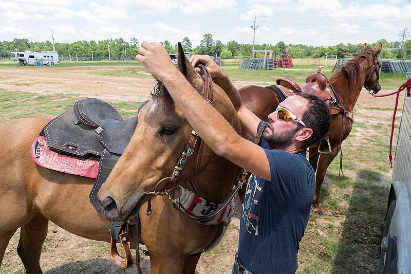 James Barnes of Hamburg, Ark., puts a saddle and reins on Don't Worry Be Happy on Thursday, June 9, 2016 at the Four States Fairgrounds. The Runnin WJ Benefit Barrel Race will take place today and Saturday.