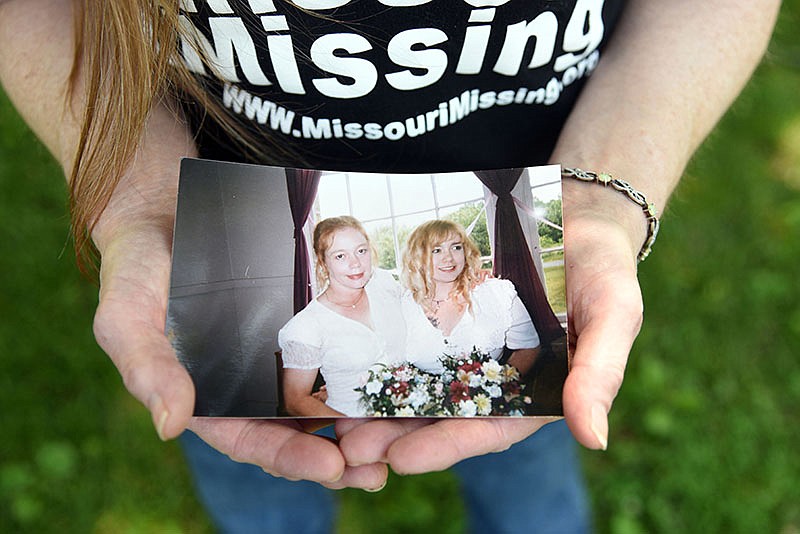 Marianne Asher-Chapman holds a picture of her daughter Angie Yarnell and her at Asher-Chapman's wedding. Asher-Chapman co-founded Missouri Missing, an organization that helps families cope and find their missing loved ones. 