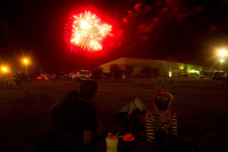 Eric Knop, Christina Moss, and Braden Knop watch fireworks explode in 2014 over the arena at the Four States Fairgrounds in Texarkana, Ark., during the Sparks in the Park celebration.