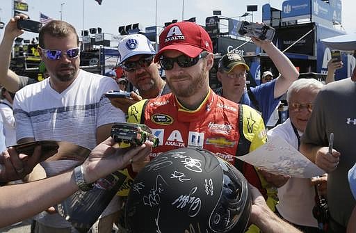 Fans surround driver Dale Earnhardt Jr. seeking autographs before a practice session for the NASCAR Sprint Cup series auto race at Michigan International Speedway, Saturday, June 11, 2016 in Brooklyn, Mich.