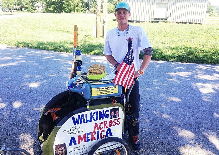 Brett Bramble stops in Tebbetts, Mo., on his way to San Francisco during his coast-to-coast hike. He said he is walking for his sister, who died in 2014 of a drug overdose.