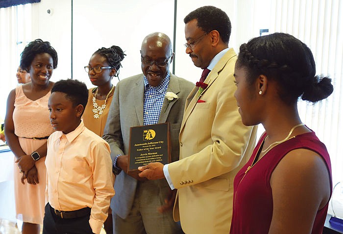 W.T. Edmonson, second from right, presents the Father of the Year Award to Jervis Mornan during Sunday's Juneteenth Heritage Celebration Father's Day Awards Banquet at Lincoln University. Mornan's children, standing beside him along with his wife, read their written nominations before the award was presented.