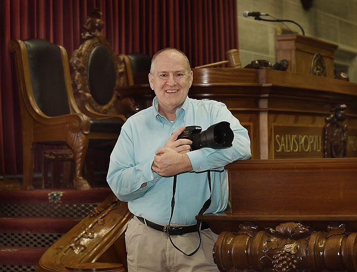 Missouri House of Representatives photographer Tim Bommel poses for a photograph at the speaker's dais on the floor of the Missouri House. 
