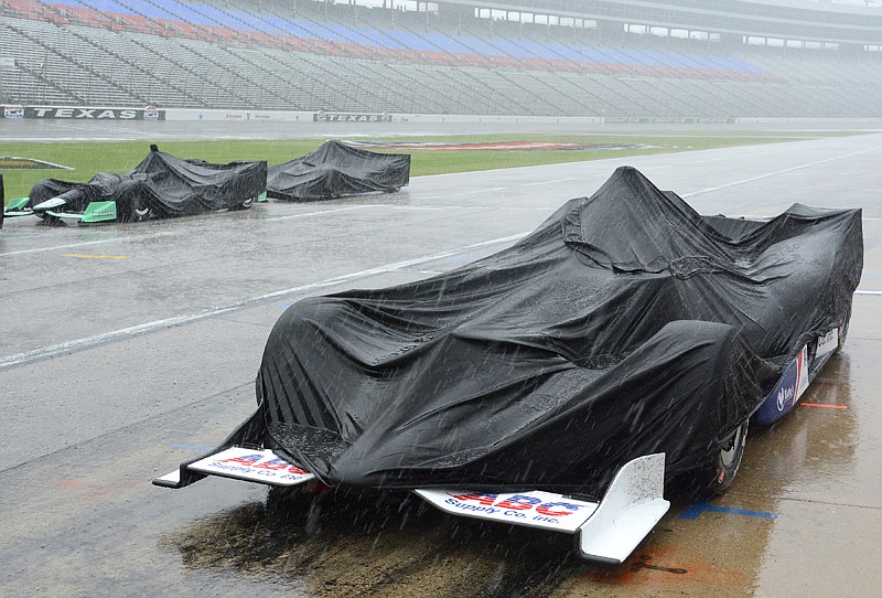 Cars are covered by tarps during a thunderstorm, which stopped an IndyCar race Sunday at Texas Motor Speedway in Fort Worth, 